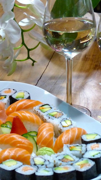 Plateau de sushis, orchidée et verres de vin